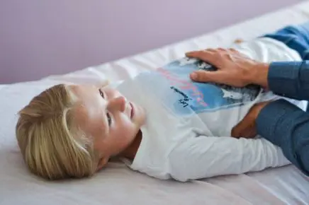 Mädchen wird behandelt mit Hand auf dem Bauch